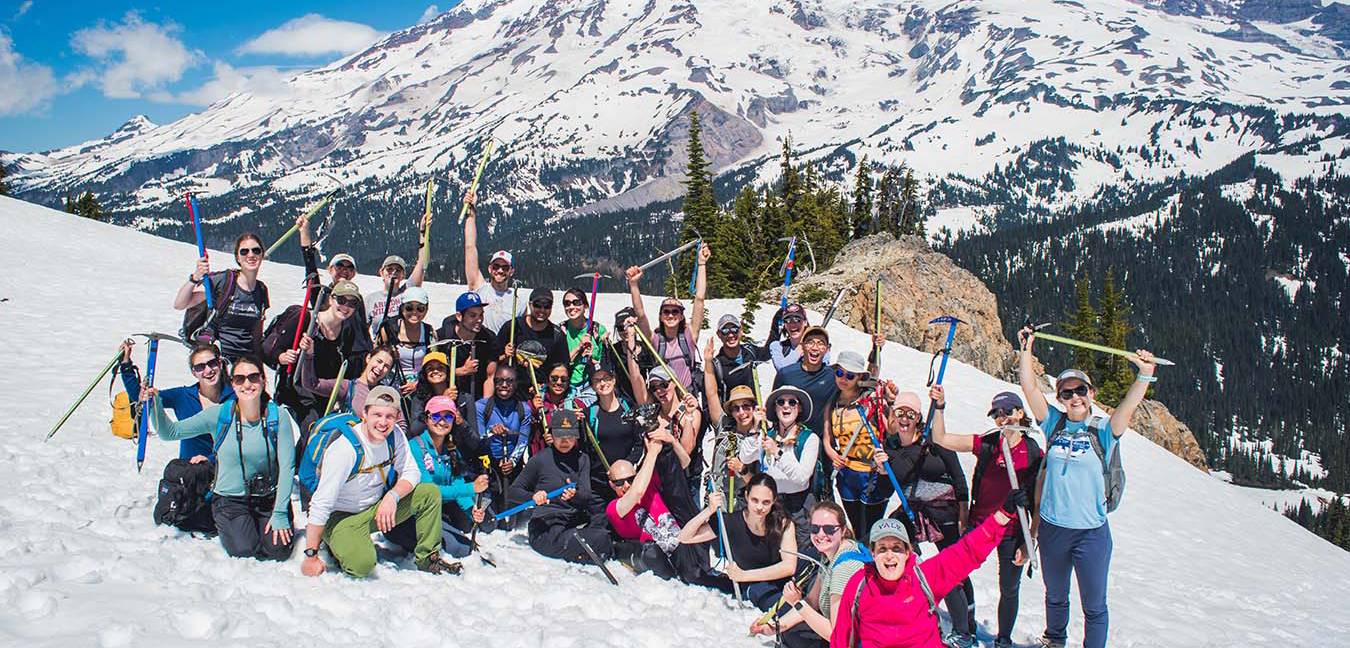 Large group of residents posing on a snowy mountain with ice picks